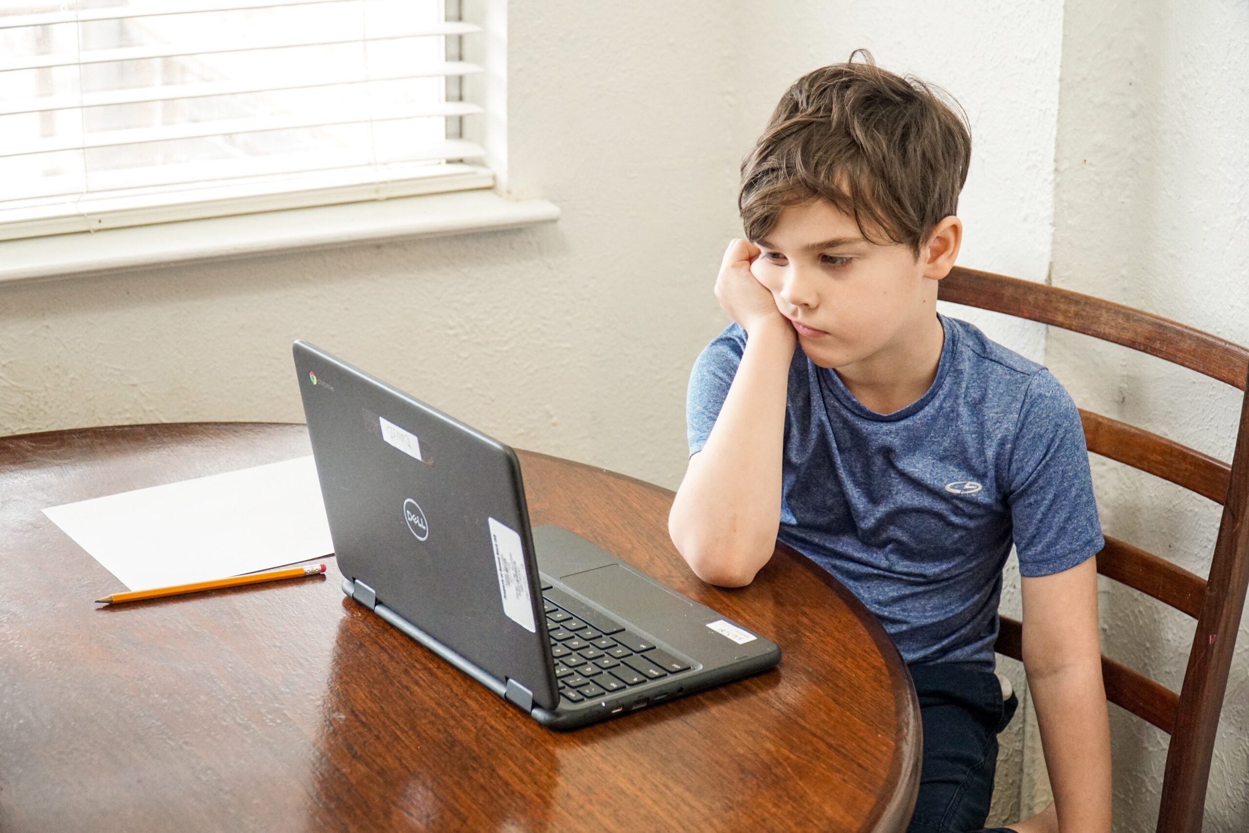 unmotivated, bored student looking at his laptop