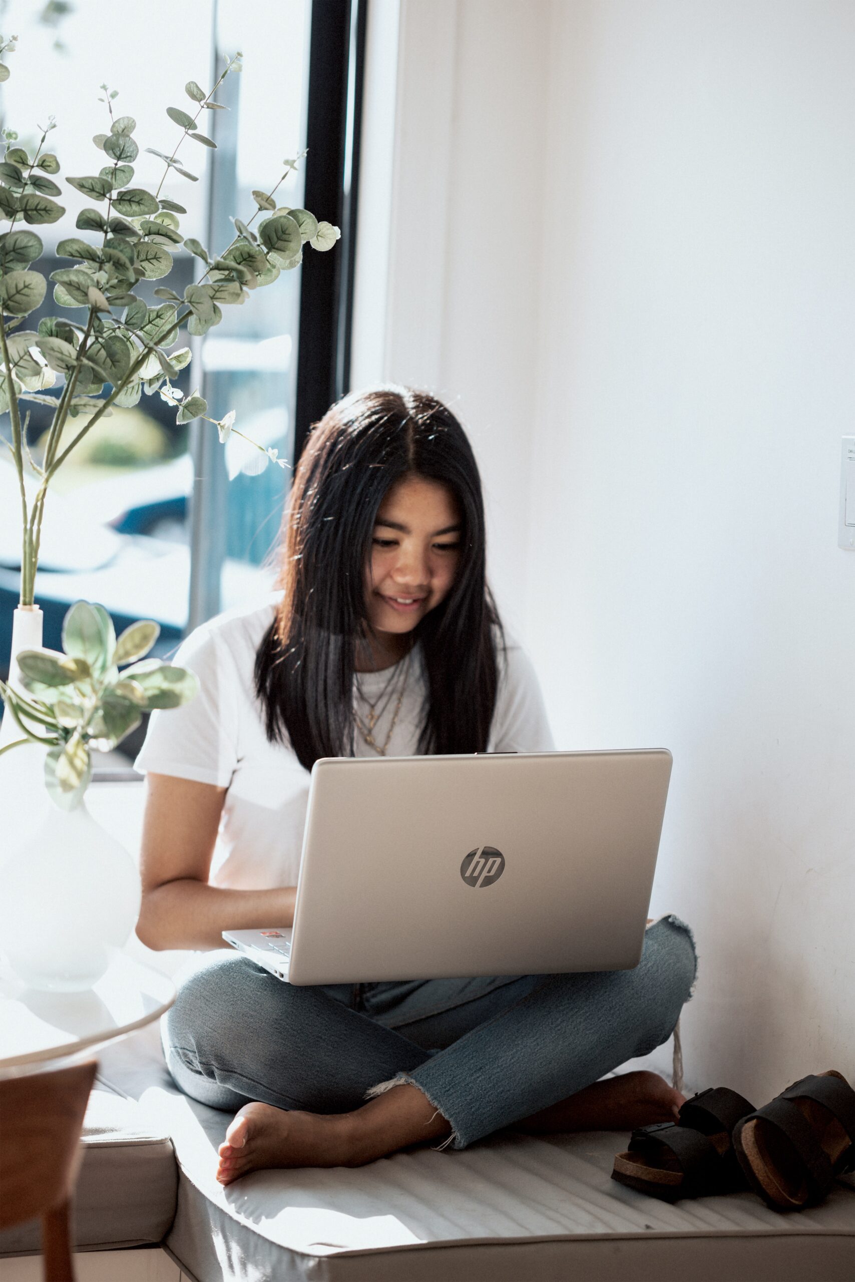 student sitting in a corner on her laptop