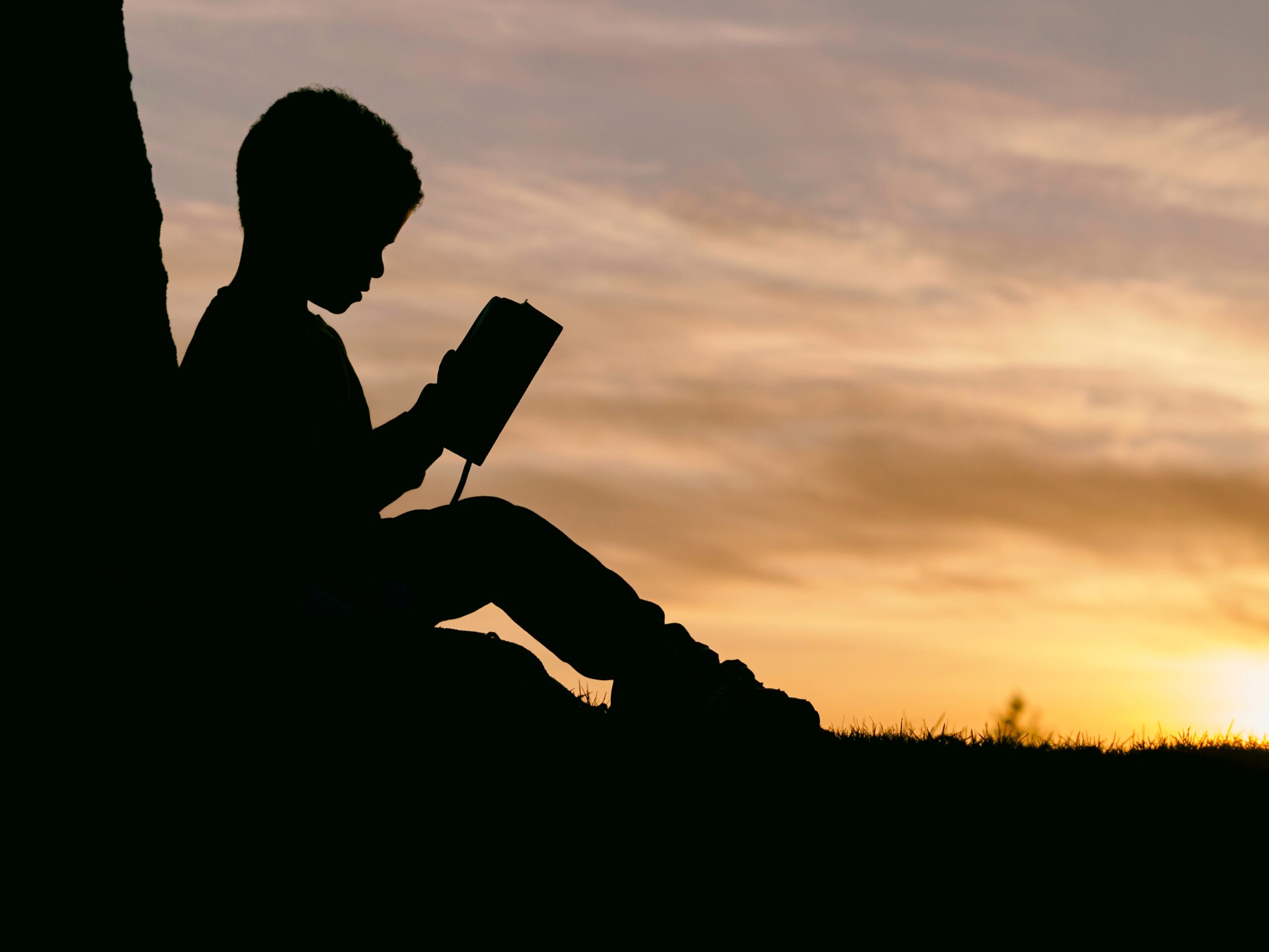 Child-reading-against-a-tree