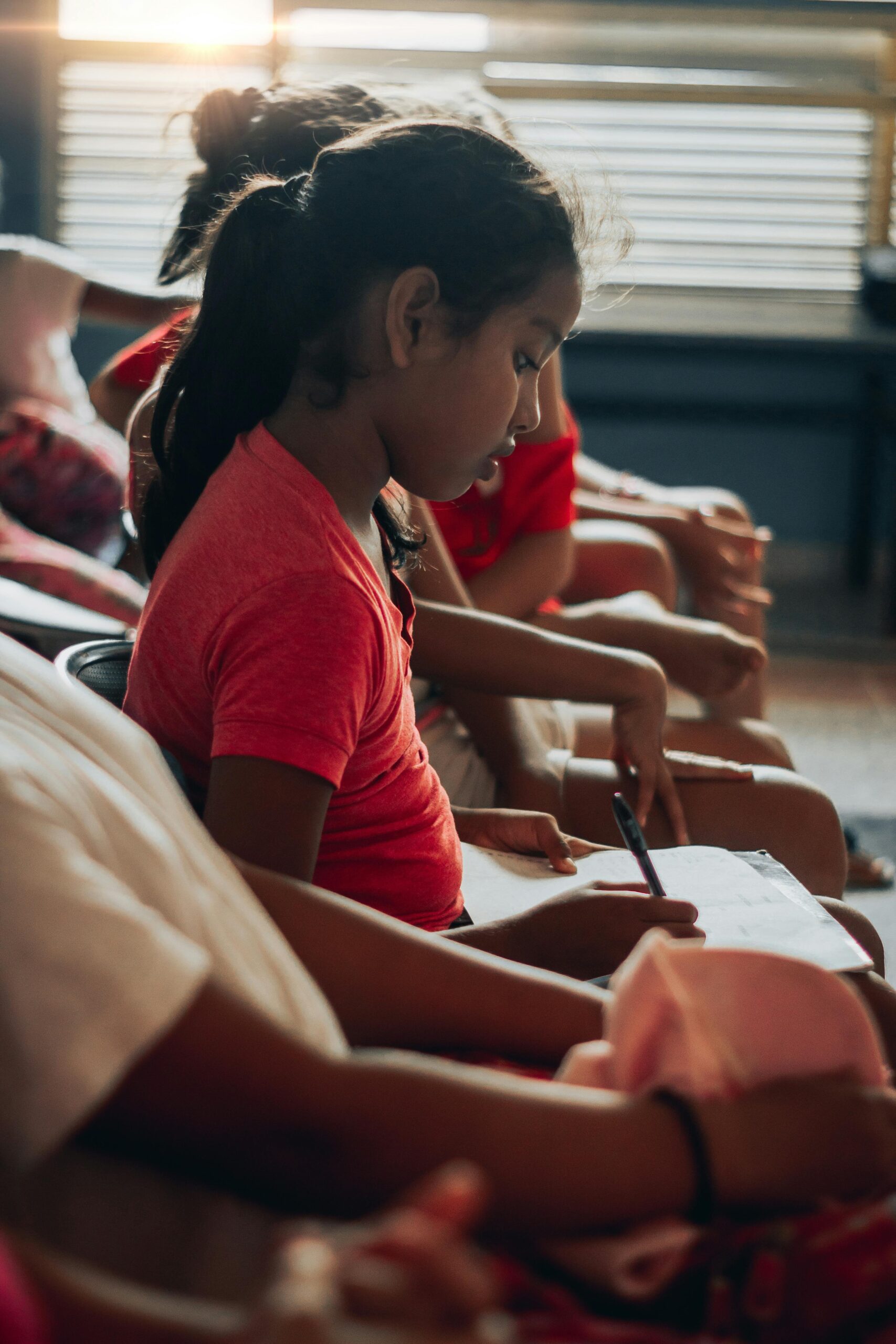 young girl in red shirt taking a dyslexia screener