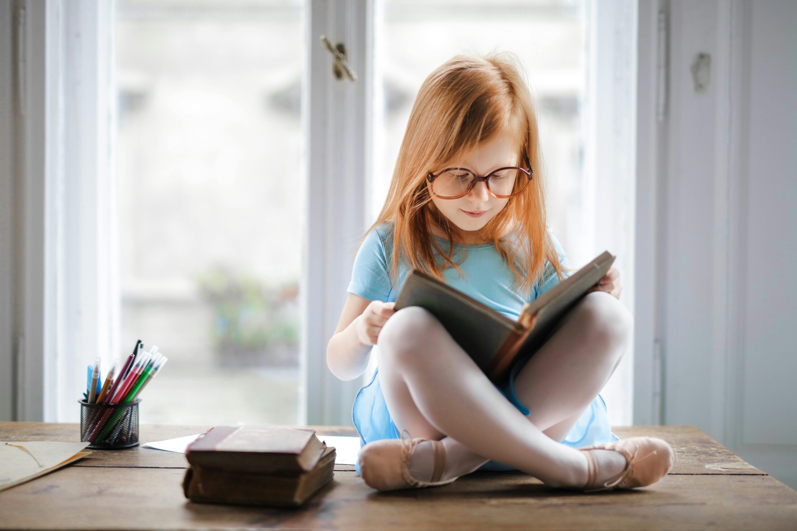 student sitting on a table reading a book