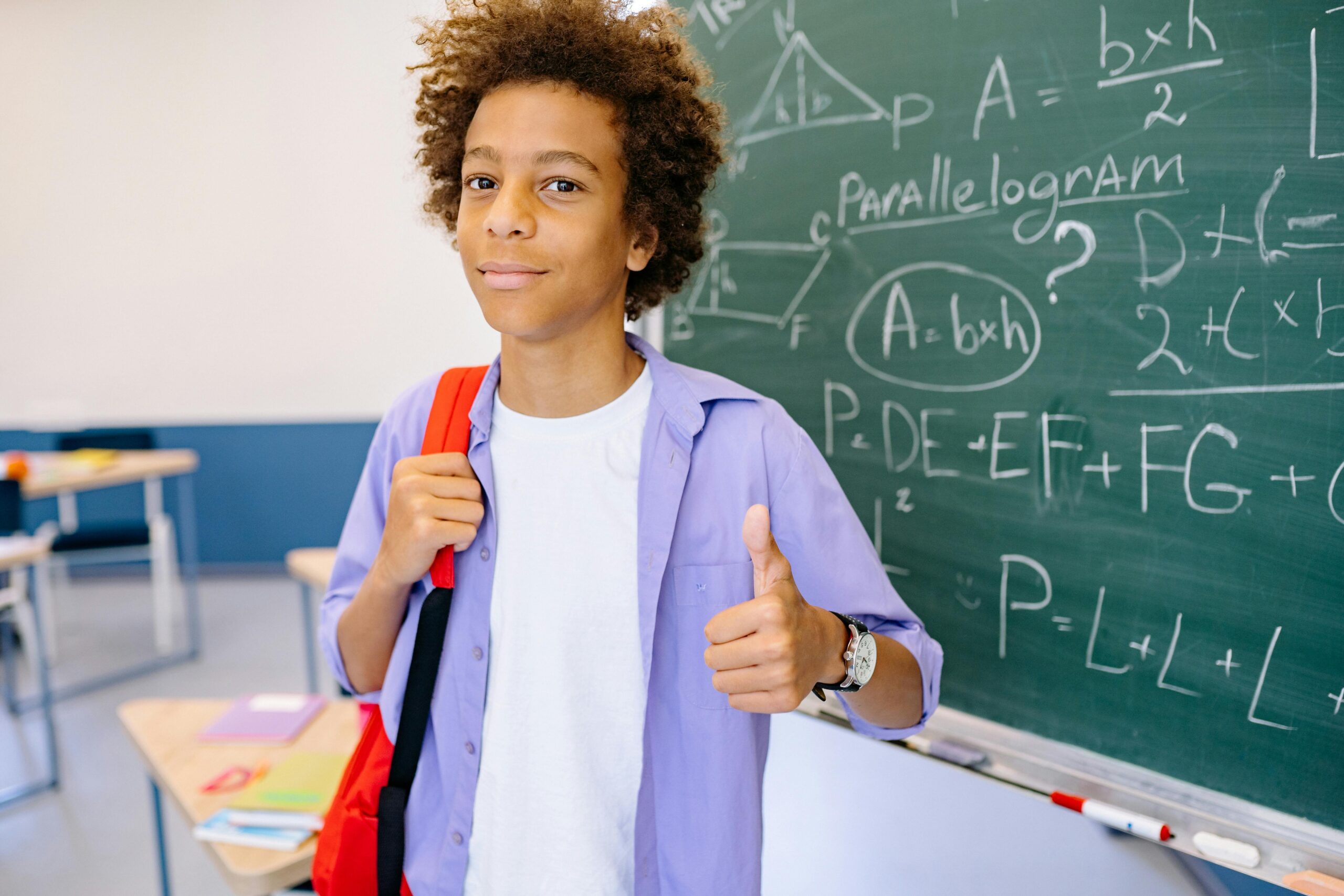 student standing in front of a blackboard