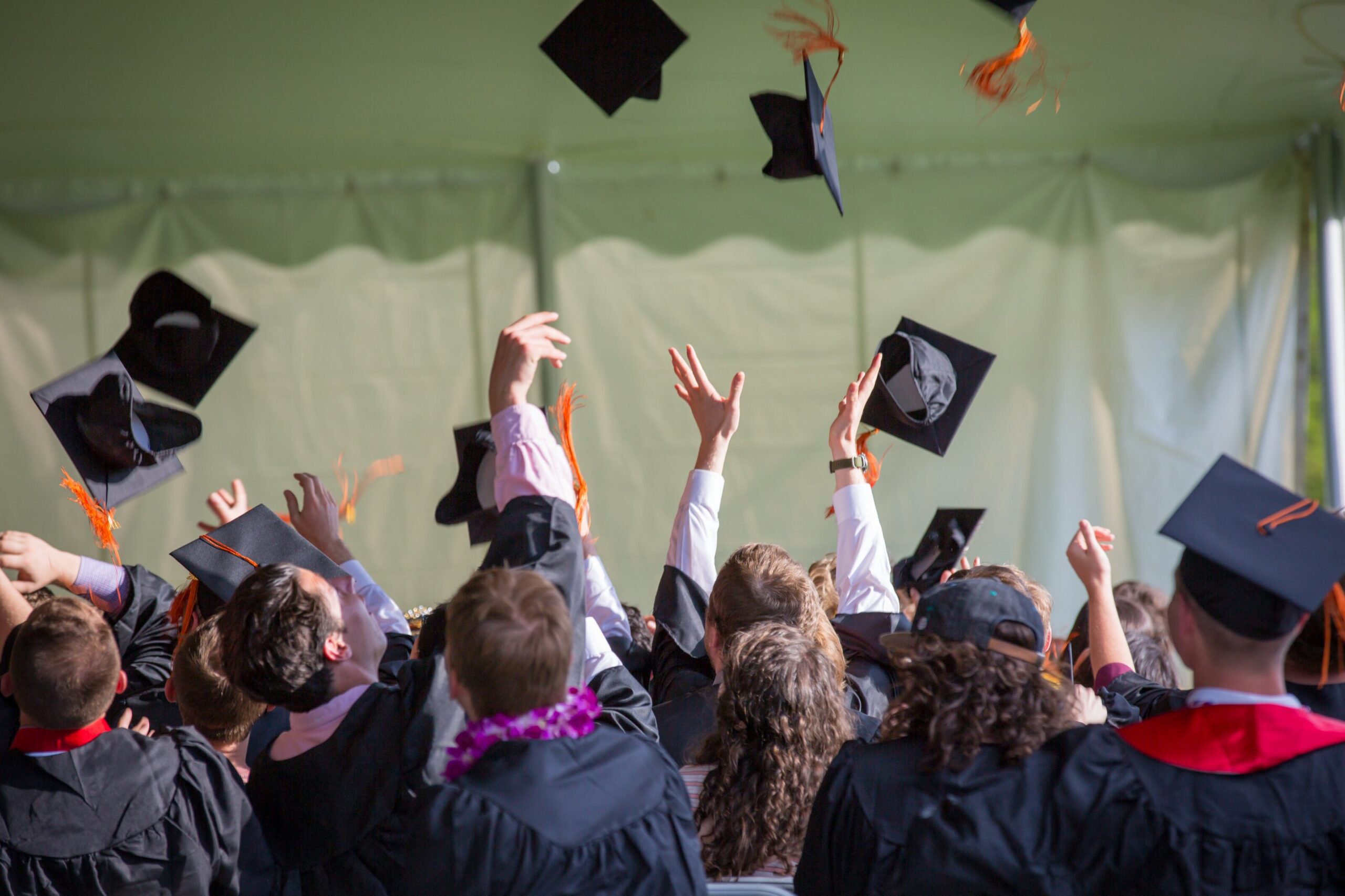 students throwing caps in the air at a graduation